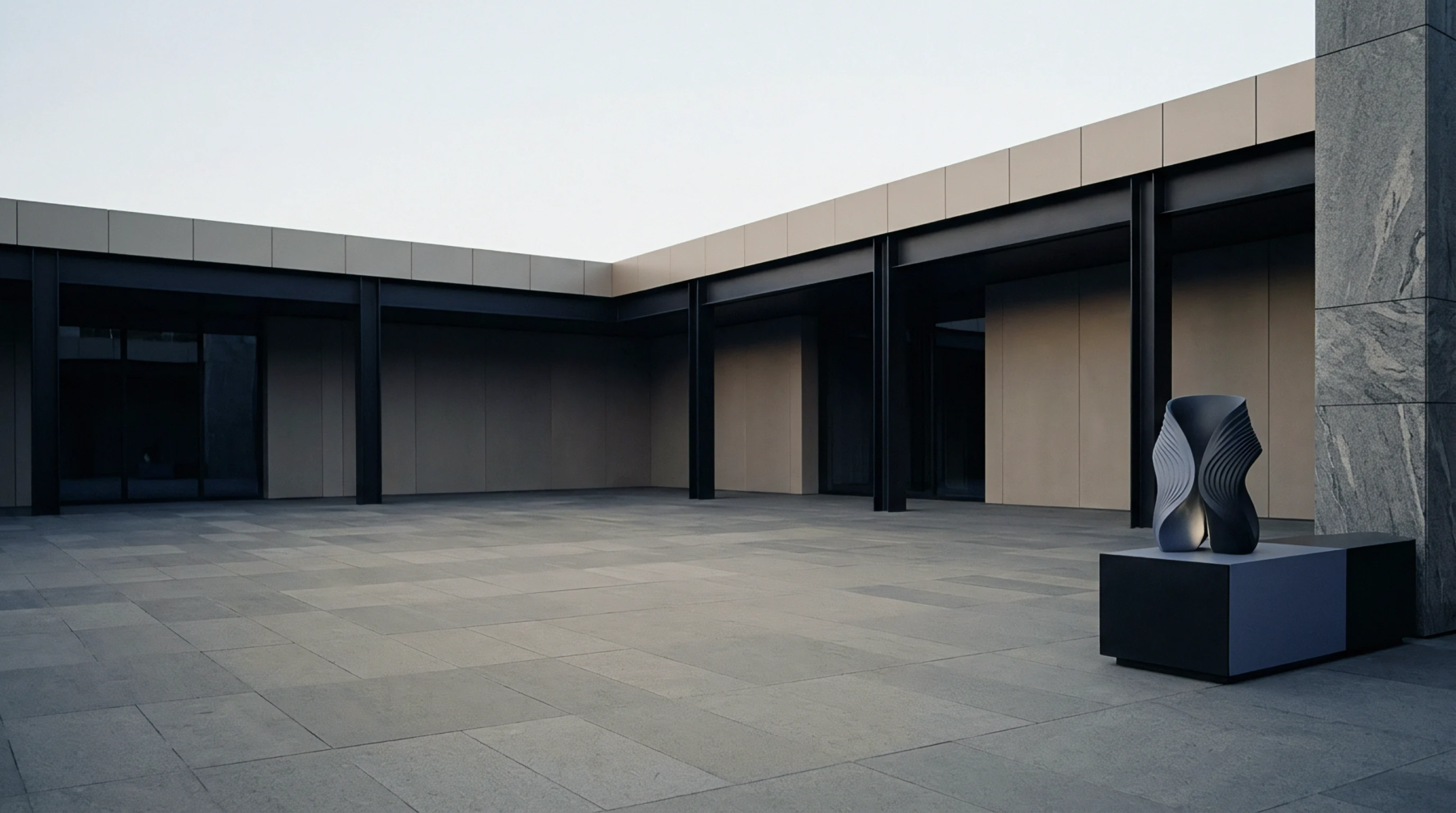 An expansive industrial courtyard features dark structural steel beams and concrete panels framing an empty production support zone with an abstract geometric pedestal sculpture.