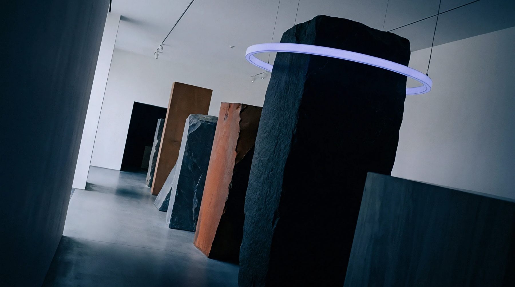 Monolithic stone and steel slabs stand in a sequential line on a concrete floor within a minimalist white gallery space.