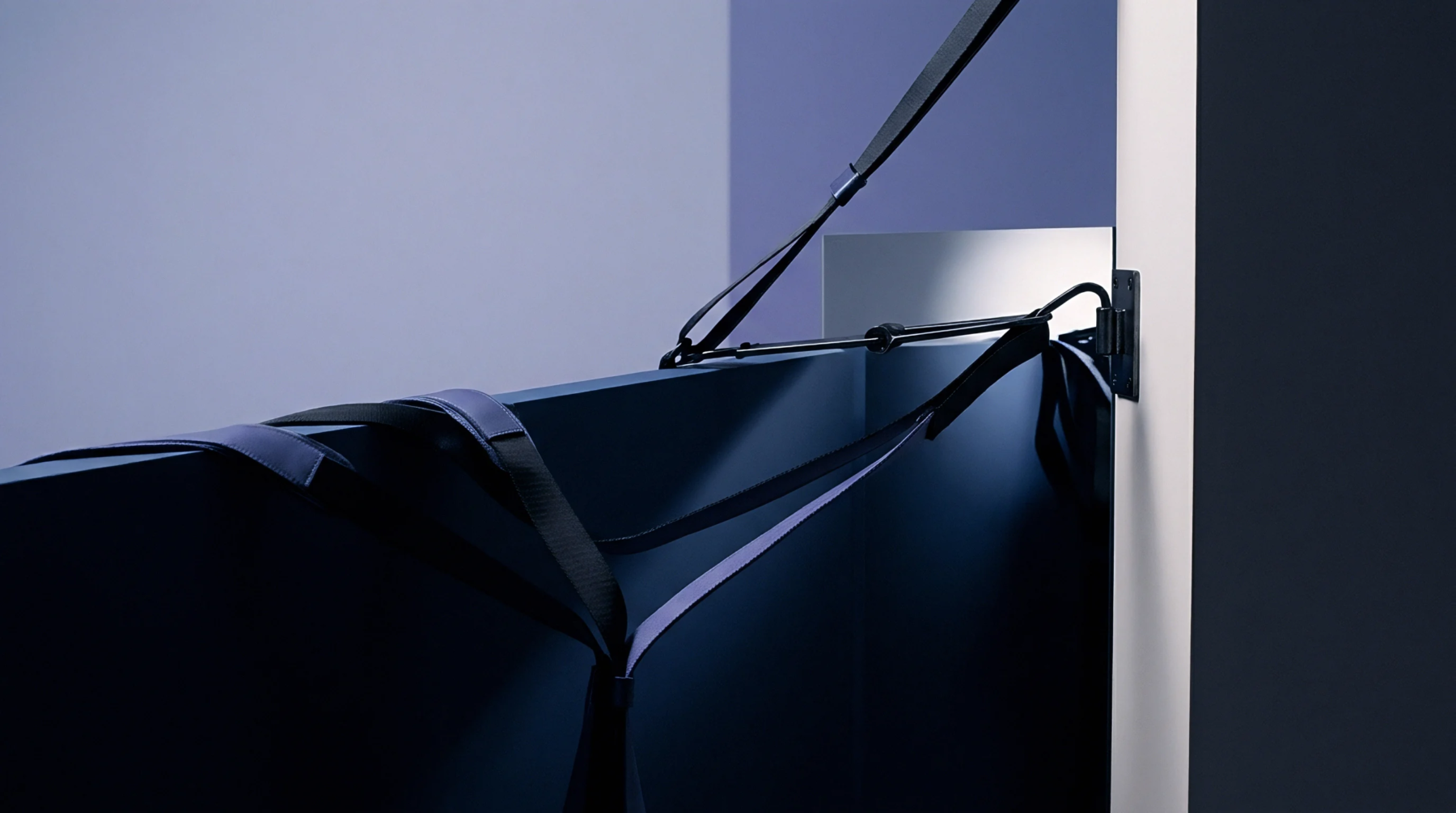 A digital render presents a wall mounted industrial assembly assist tether system featuring textile straps attached to a steel bracket.